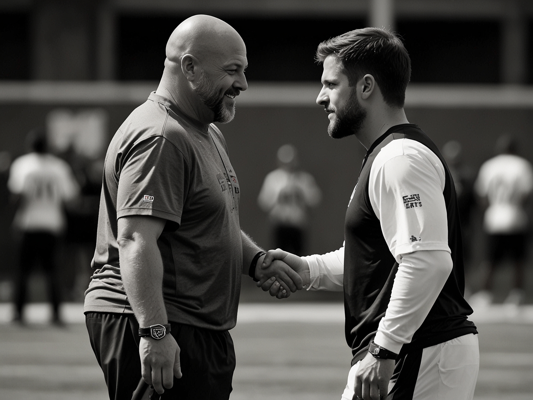 New York Giants' head coach Brian Daboll shaking hands with Jacob Saylors during a training session, symbolizing Saylors' integration into the team's offensive schemes and the new dynamic he brings.